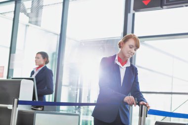 Çekici genç yolcu hizmetleri görevlisinin portresi havaalanında yolcu alımı için kapıyı açıyor.