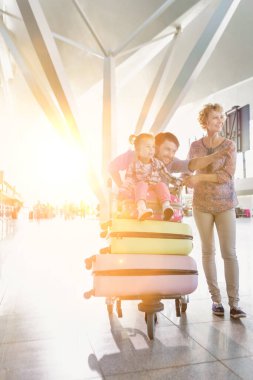 Havaalanına tatile giden mutlu bir ailenin portresi.