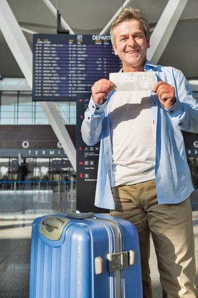 Portret Szczęśliwego Dojrzałego Mężczyzny Pokazujący Swoją Kartę Pokładową Lotnisku — Zdjęcie stockowe