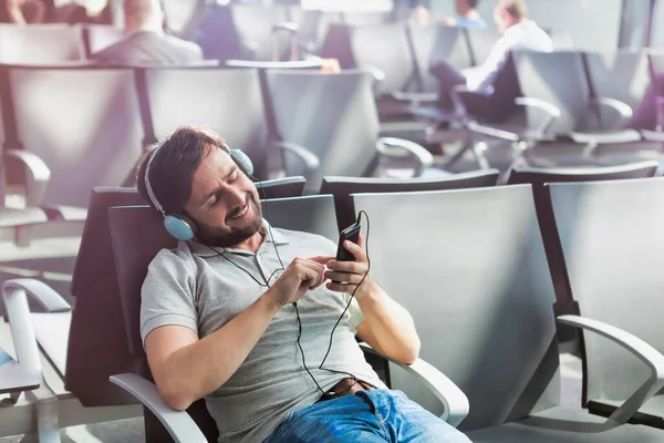 Retrato Del Hombre Usando Smartphone Con Auriculares Encendidos Mientras Espera — Foto de Stock