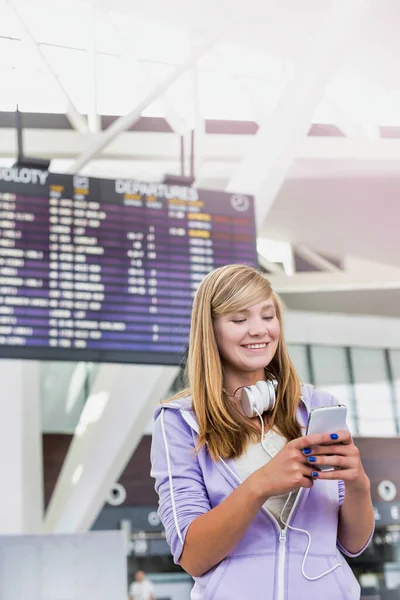 レンズフレアと空港でスマートフォンを使用して若い美しい十代の女の子の肖像画 — ストック写真