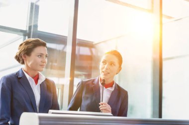 Havaalanında duran, gülümseyen, çekici genç bir servis elemanı portresi.