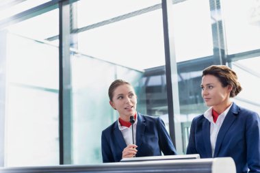 Havaalanında duran, gülümseyen, çekici genç bir servis elemanı portresi.