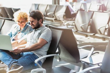 Bir adamın havaalanında beklerken karısıyla birlikte komik bir resim göstermesi.