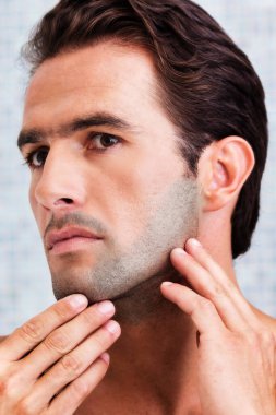 Çekici adamın portresi aynada yüzünü kontrol ediyor.