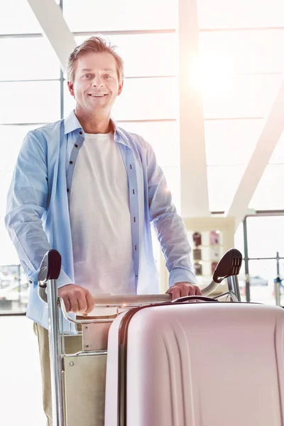 一个成熟而有魅力的男人提着手提箱在机场办理登机手续的画像 — 图库照片