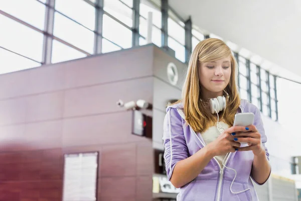 レンズフレアと空港でスマートフォンを使用して若い美しい十代の女の子の肖像画 — ストック写真