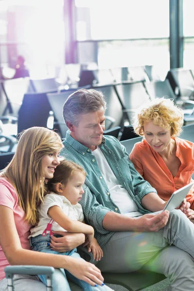 彼の妻と娘が空港で見ている間 デジタルタブレットを使用して成熟した男 — ストック写真
