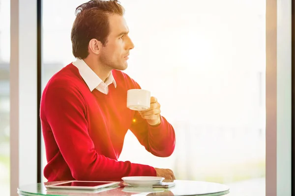 Jovem Empresário Atencioso Sentado Enquanto Bebe Café Lobby Com Clarão — Fotografia de Stock