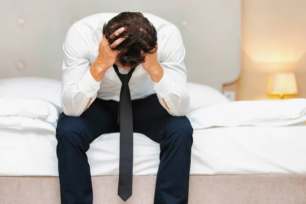 ベッドの上に座っているストレスと過労のビジネスマン — ストック写真