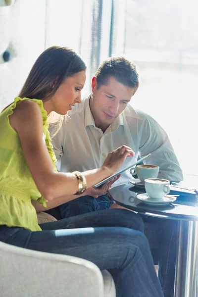 コーヒーを飲みながら ビジネスマンにデジタルタブレット上の計画を議論ビジネス女性 — ストック写真