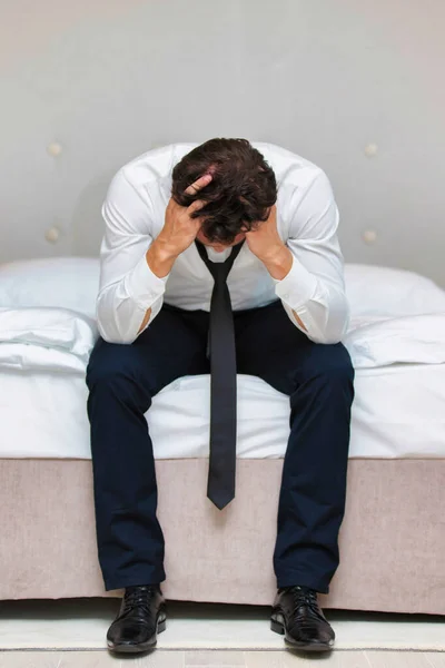 ベッドの上に座っているストレスと過労のビジネスマン — ストック写真