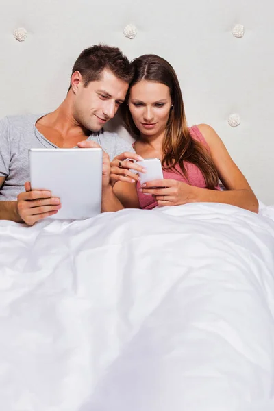 Erkek Arkadaşı Yatakta Dijital Tabletinde Oyun Oynarken Akıllı Telefon Gösteren — Stok fotoğraf