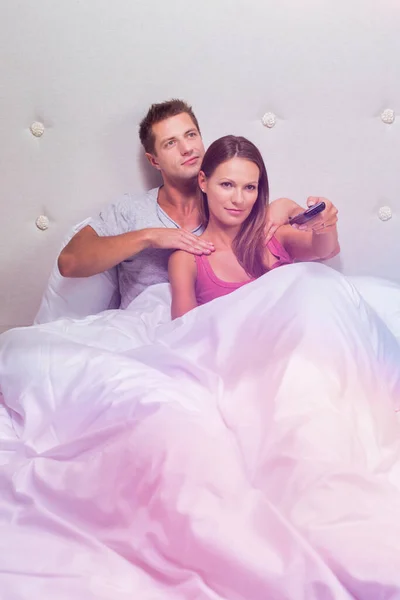 Mann Massiert Seine Frau Beim Fernsehen Bett — Stockfoto