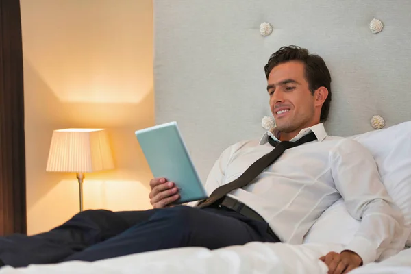 사업가 가집에서 디지털 태블릿을 사용하면서 침대에 — 스톡 사진