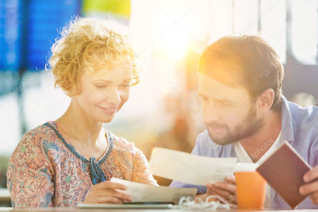 Mature couple looking at their boarding passes in airport