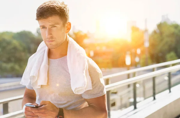 Portret Młodego Atrakcyjnego Mężczyzny Stojącego Ręcznikiem Ramionach Podczas Korzystania Smartfona — Zdjęcie stockowe