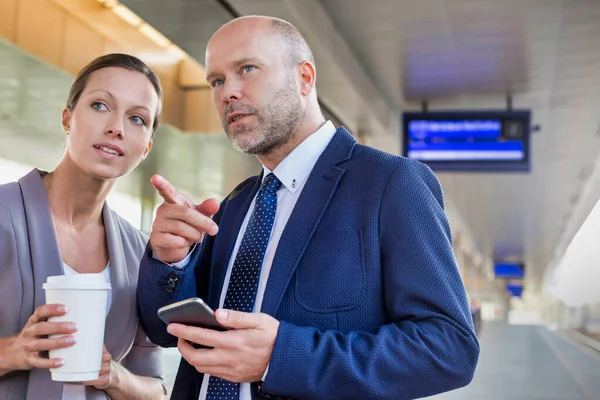 Retrato Empresário Gesticulando Enquanto Conversa Com Jovem Atraente Empresária Estação — Fotografia de Stock