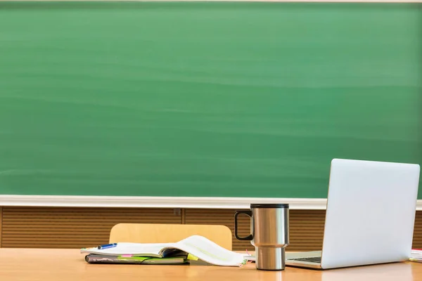 Foto Portátil Escritorio Del Profesor Con Vaso Libro Contra Pizarra —  Fotos de Stock