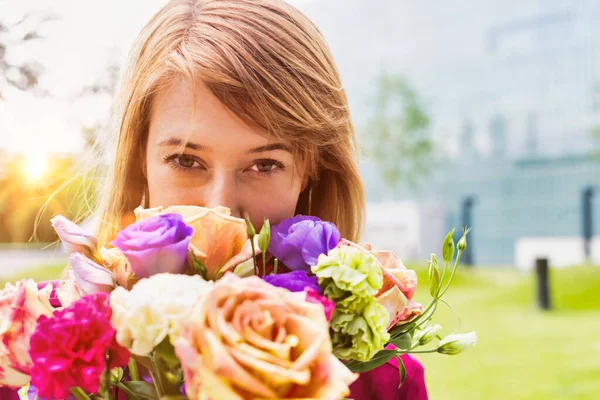 花の花束を持つ若い魅力的な女性の肖像 — ストック写真
