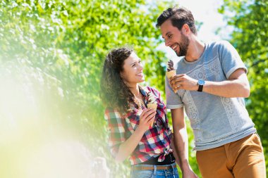 Dondurma yerken yürüyen genç ve çekici bir çiftin portresi