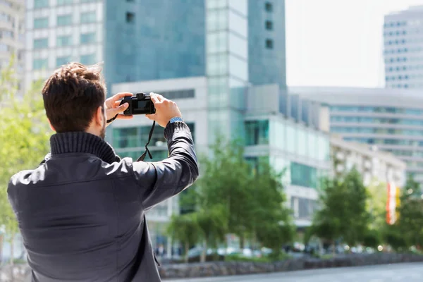 若い魅力的な男が背景にレンズフレアで街の美しい景色を撮影 — ストック写真