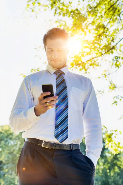 スマートフォンを使用してハンサムな成熟したビジネスマンの低角度ビュー — ストック写真