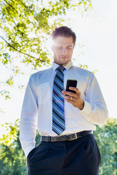スマートフォンを使用してハンサムな成熟したビジネスマンの低角度ビュー — ストック写真