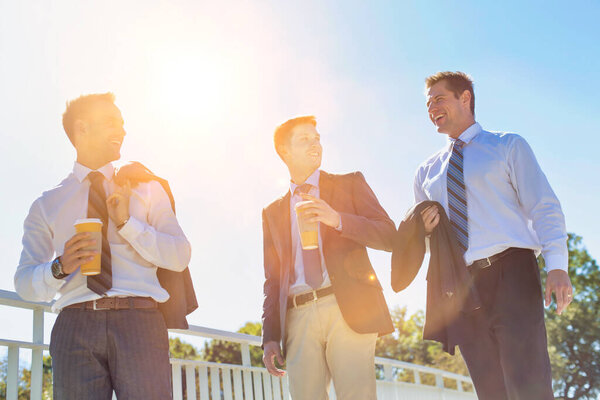 Бизнесмены пьют кофе во время прогулок и бесед во время перерыва
