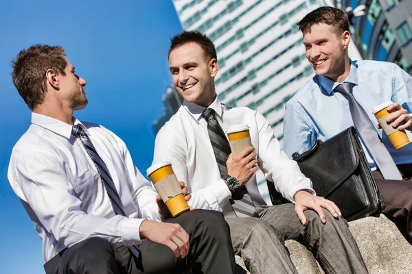 仕事の後にコーヒーを飲みながら座って話をする同僚のグループ — ストック写真