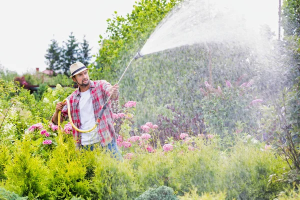 ガーデンショップの男性庭師散水植物の写真 — ストック写真
