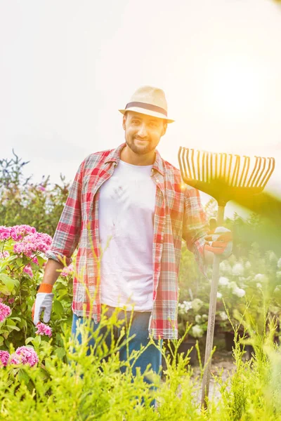 フォークレーキを保持しながら立って成熟した庭師の肖像 — ストック写真