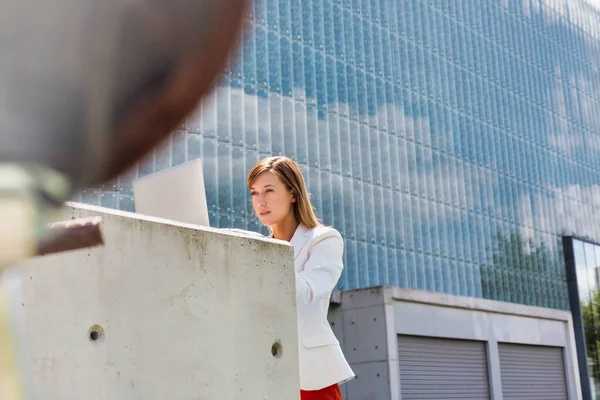 若い魅力的なビジネスマンの肖像画彼女のラップトップの屋外で働いている — ストック写真