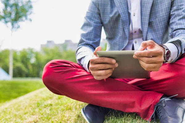 Retrato Jovem Empresário Atraente Usando Tablet Digital Enquanto Sentado Grama — Fotografia de Stock