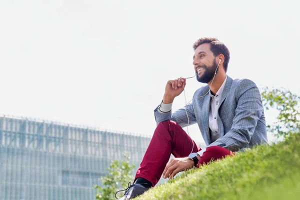 Young Attractive Businessman Talking Smartphone Earphones While Sitting Grass — Stock Photo, Image
