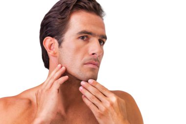 Adamın aynada yüzünü kontrol etmesi.