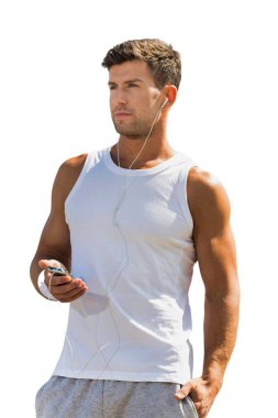 Genç, aktif ve çekici bir adamın akıllı telefonunda kulaklık takıp müzik dinlemesini kes. 