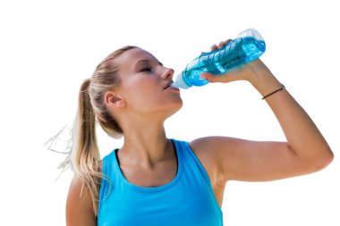 Enerji içeceği içerken spor kıyafeti giyen aktif bir kadın.