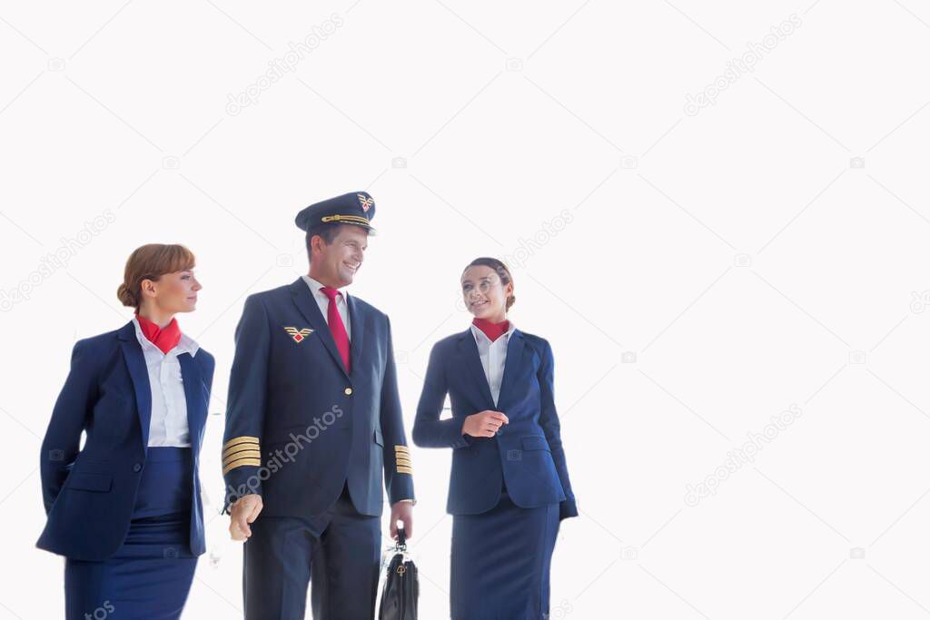 Cutouts of mature pilot walking with beautiful flight attendants