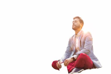 Genç düşünceli iş adamı beyaz tablet üzerinde oturup dijital tablet tutuyor.