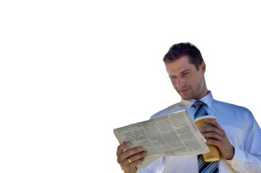 Mola sırasında parkta gazete okurken elinde bir fincan kahve tutan yakışıklı iş adamının görüntüsü.