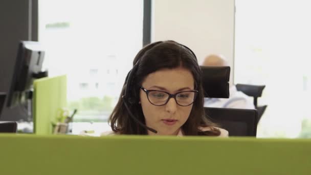 コールセンターで働く眼鏡をかけた美しいビジネス女性 — ストック動画