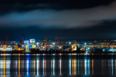 Gece Murmansk, körfeze yansıyan şehir ışıkları ve limanda duran gemiler.