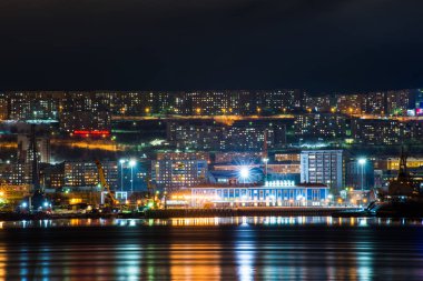 Gece Murmansk, körfeze yansıyan şehir ışıkları ve limanda duran gemiler.