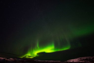 Tepeler, berrak yıldızlı gökyüzü ve renkli kuzey ışıkları, inanılmaz bir doğa olayı.