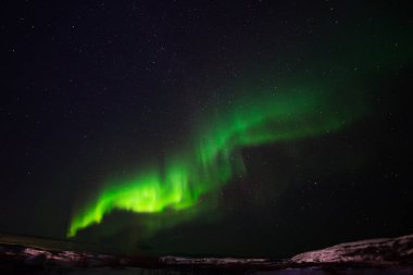 Tepeler, berrak yıldızlı gökyüzü ve renkli kuzey ışıkları, inanılmaz bir doğa olayı.