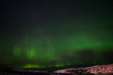 Tepeler, berrak yıldızlı gökyüzü ve renkli kuzey ışıkları, inanılmaz bir doğa olayı.