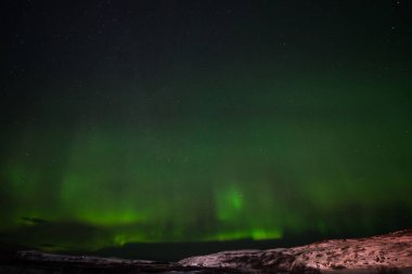 Tepeler, berrak yıldızlı gökyüzü ve renkli kuzey ışıkları, inanılmaz bir doğa olayı.