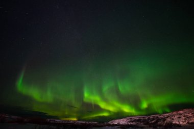 Tepeler, berrak yıldızlı gökyüzü ve renkli kuzey ışıkları, inanılmaz bir doğa olayı.