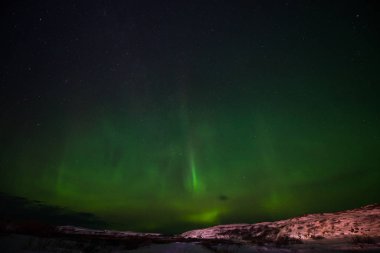 Tepeler, berrak yıldızlı gökyüzü ve renkli kuzey ışıkları, inanılmaz bir doğa olayı.